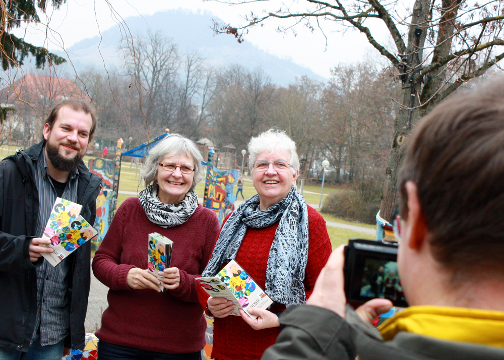 Gruppenbild mit Hausberg: Während sich die Achalm in Grau hüllt, halten (von links) Markus Christ, Rose Henes und Elisabeth Braun den farbenfrohen Festival-Flyer in die Kamera.
